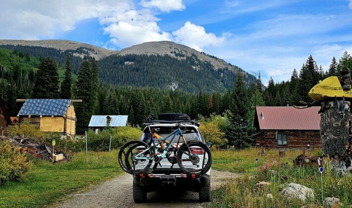photo of a white Land Rover Discovery 5 in front of some cabins