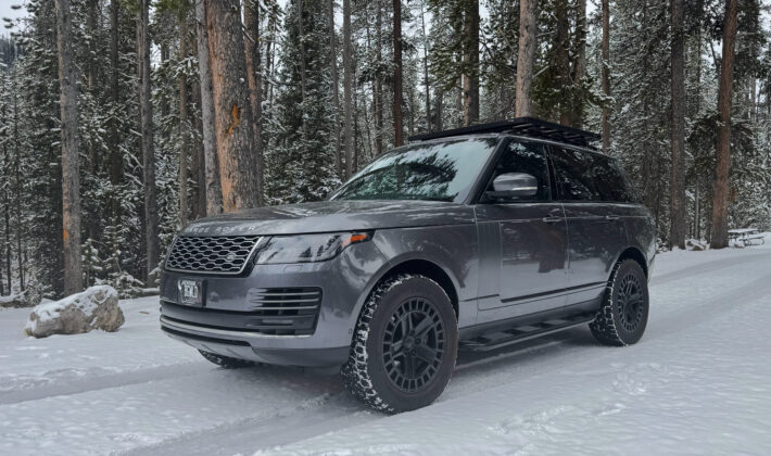 photo of a grey Range Rover in a snowy forest setting