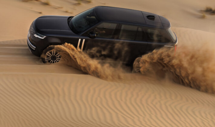 photo of an electric Range Rover driving on desert sand