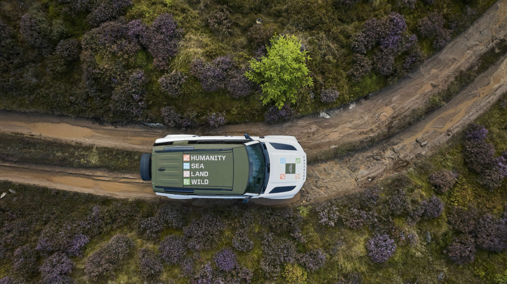 aerial image of a Defender 110 driving on a dirt road