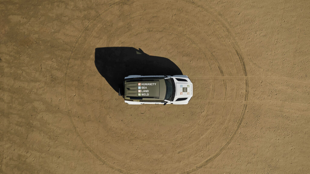 aerial image of a Defender 110 driving on a dirt road